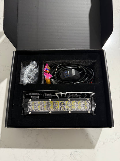 Electronic component in an open black box on a light gray surface